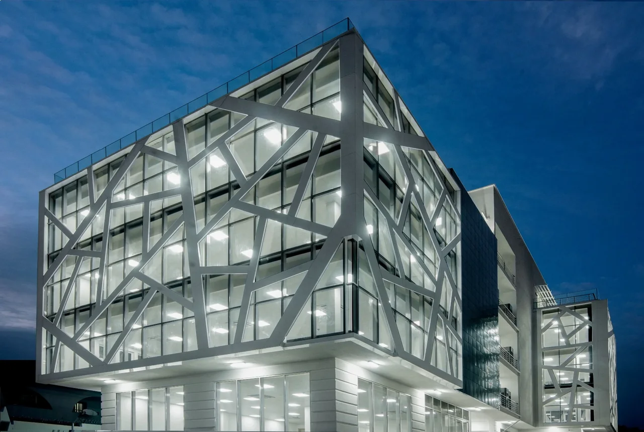 M&G Plaza at dusk, with illuminated glazing behind a geometric facade