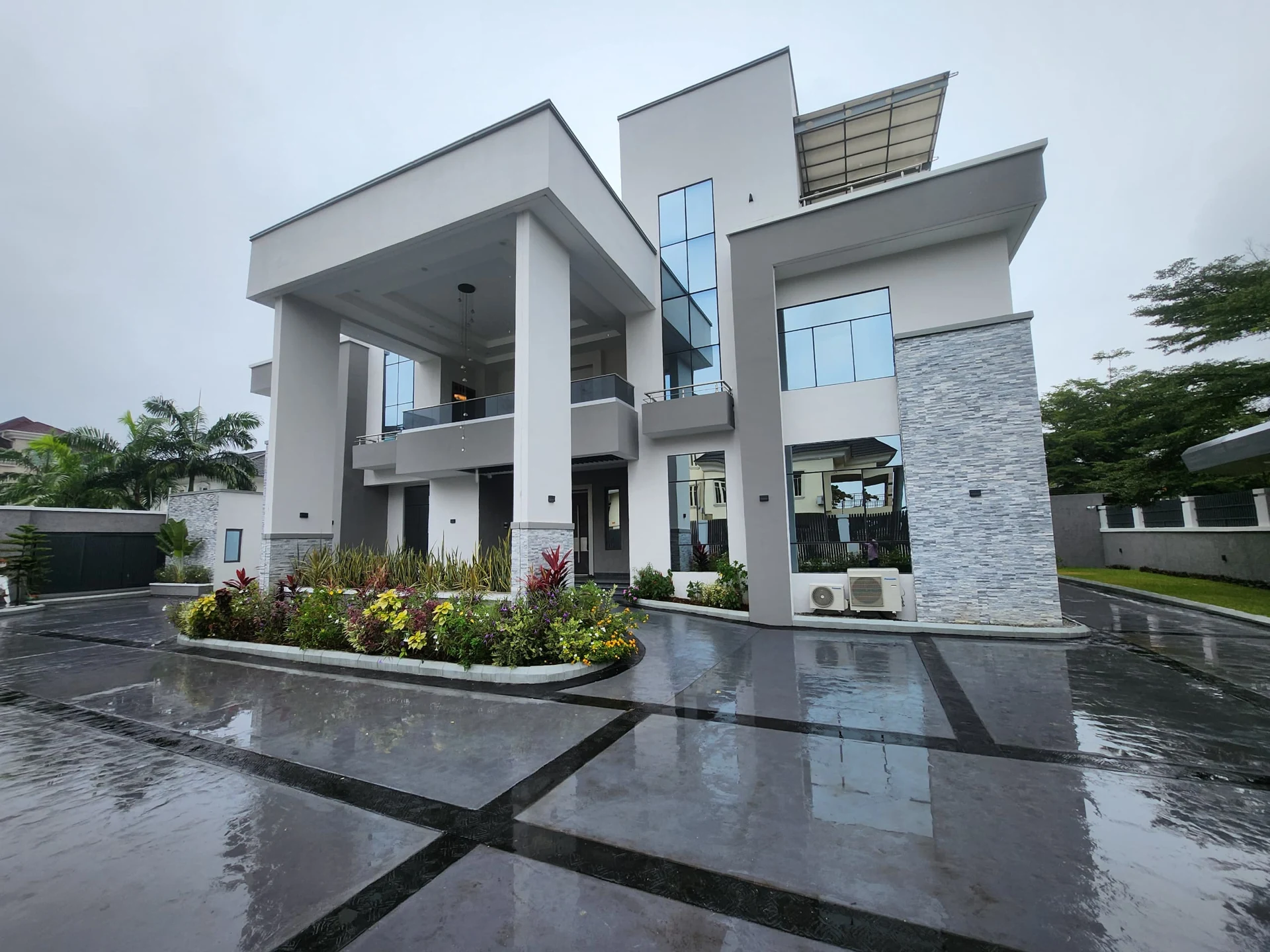 A contemporary white residence with deep terraces, generous glazing and a landscaped forecourt